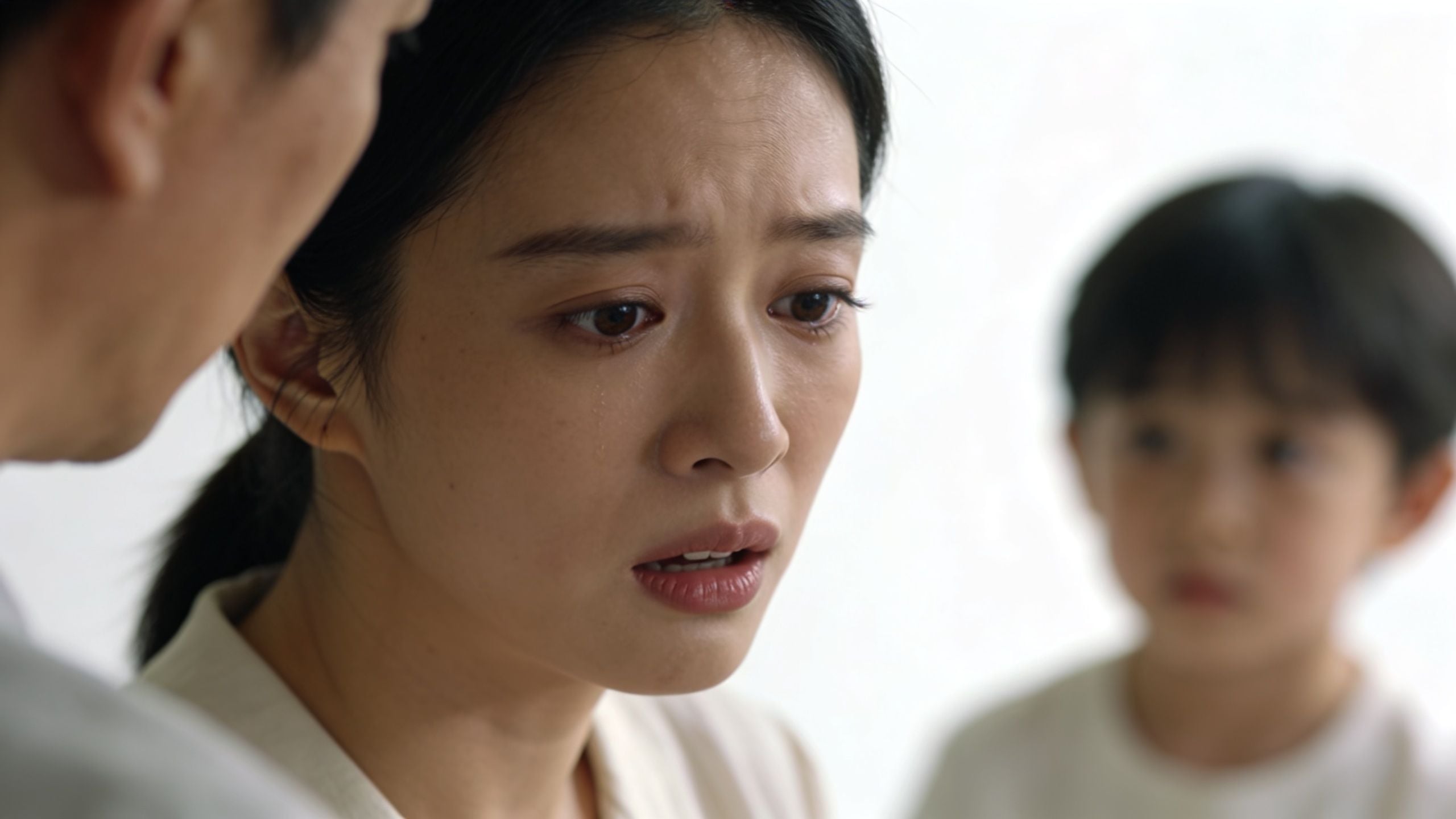 A distressed woman appearing sad or worried while looking toward a child in the background.